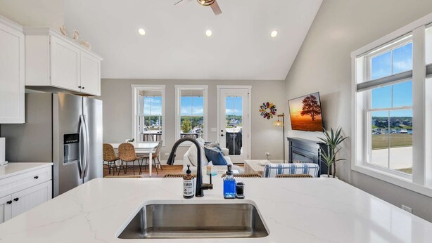 A modern kitchen with a central island, stainless steel appliances, and a view of the outdoors. - Welcome to A View to A Chill | Navvy Town Duplex (Ottawa)