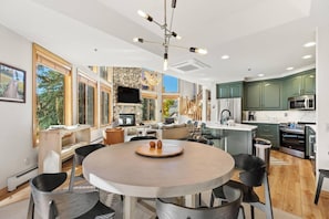 A modern kitchen with a central island, built-in appliances, and a dining area with a round table.