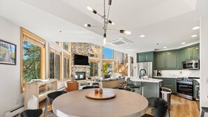 A modern kitchen with a round dining table, built-in appliances, and a stone fireplace.