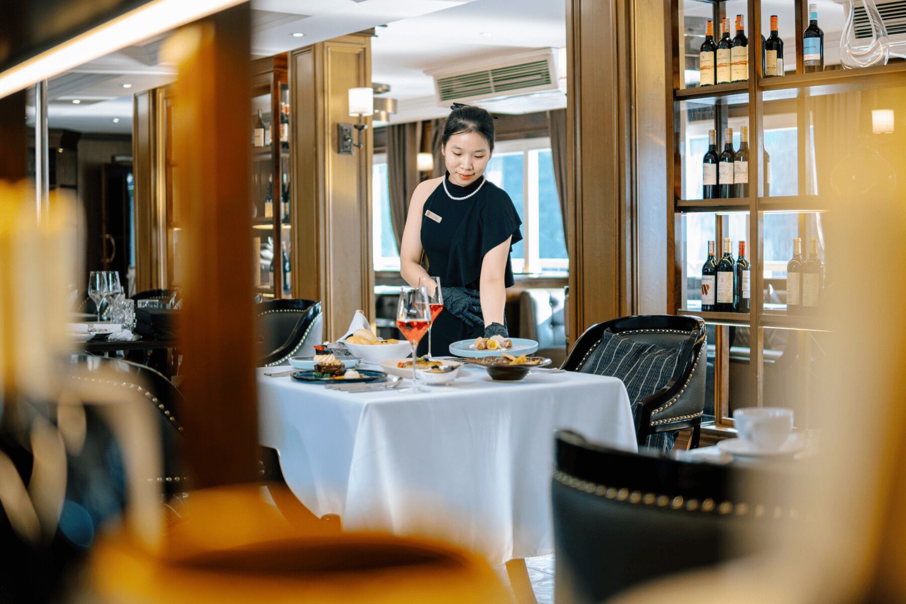 A restaurant interior with a waiter serving a table.