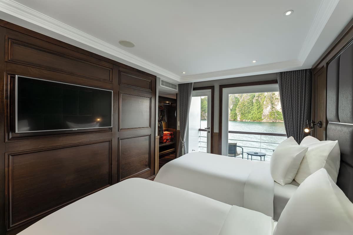Ett hotellrum med en stor säng, en tv, en garderob och utsikt över vattnet.