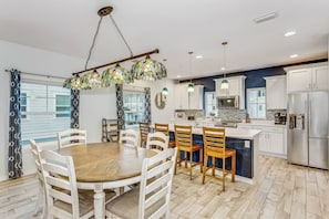 A modern kitchen with white cabinets, stainless steel appliances, and a central island.