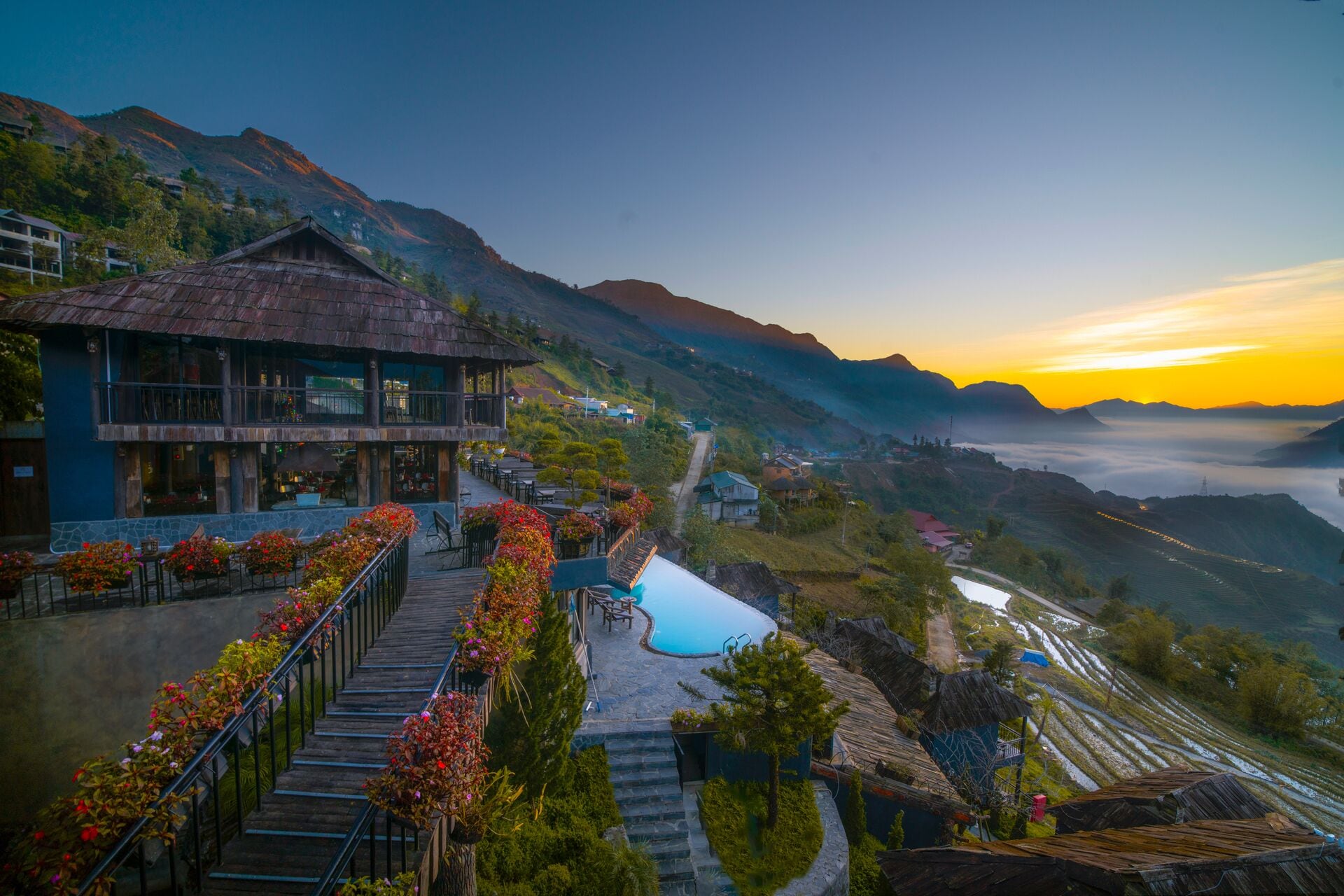Un hôtel doté d’une piscine, entouré de champs en terrasses et de montagnes.