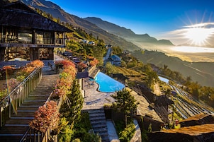 A resort with a pool, outdoor seating, and a view of the mountains.