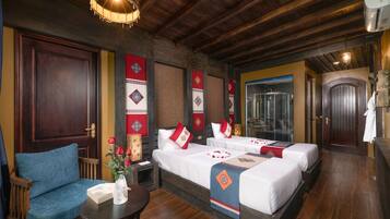 A hotel room with two beds, a wooden ceiling, and traditional decor.