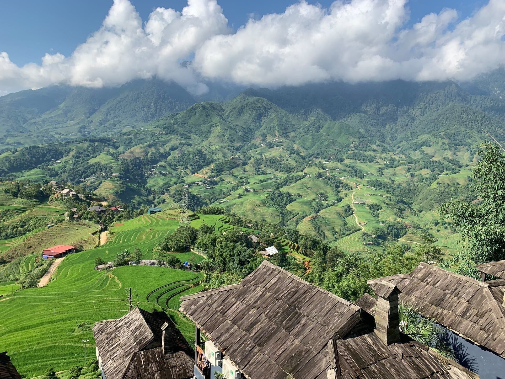 A mountainous landscape with terraced fields and traditional wooden-roofed buildings.