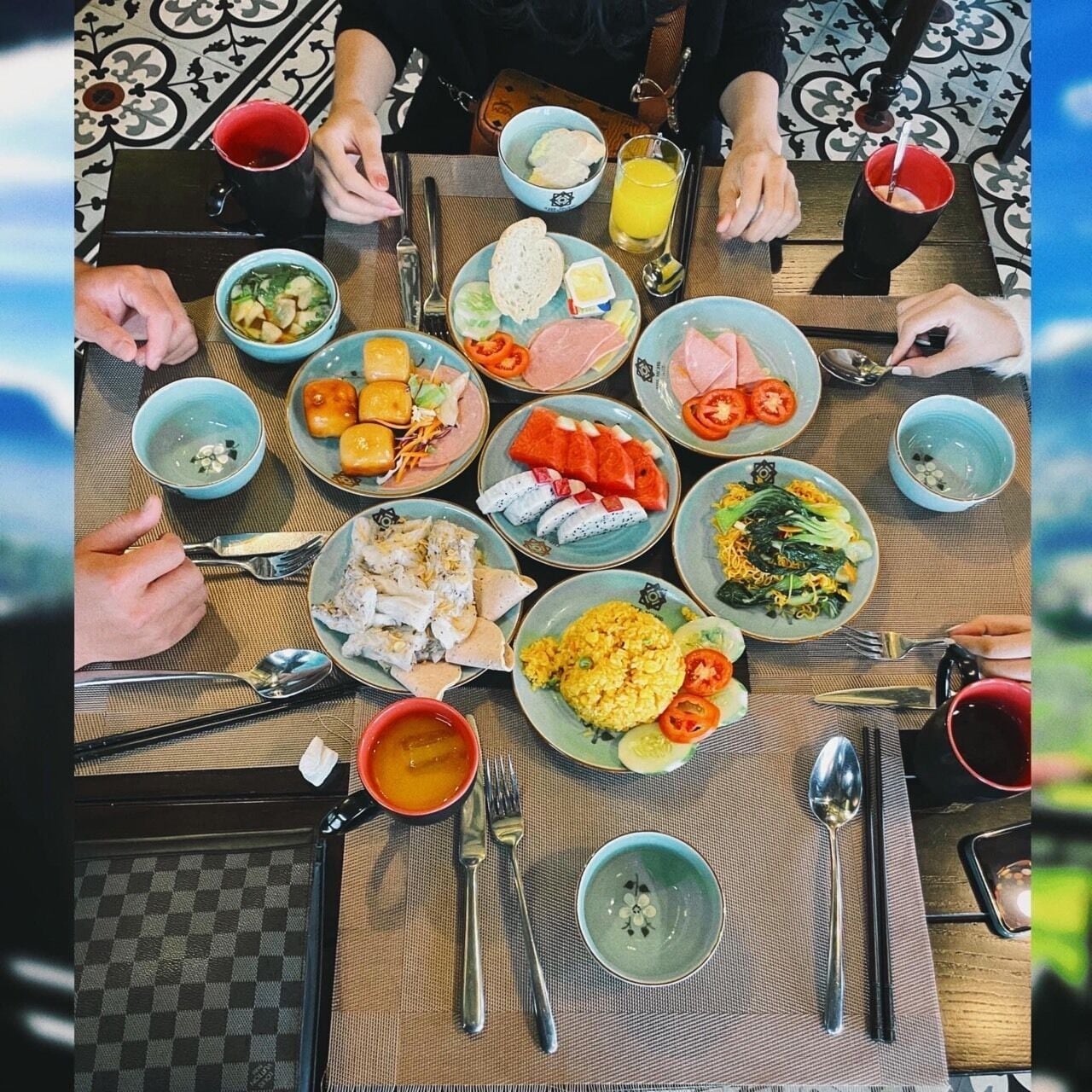 Une table dressée avec différents plats, couverts et boissons, ce qui indique qu’un repas va être servi.