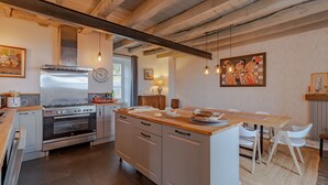 A modern kitchen with a central island, stainless steel appliances, and a rustic ceiling. - Holiday Home 'La Dordogne En Périgord' with Private Pool, Private Terrace and Wi-Fi (Salagnac)