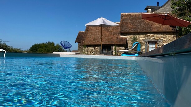 A clear swimming pool with a stone building in the background. - Holiday Home 'La Dordogne En Périgord' with Private Pool, Private Terrace and Wi-Fi (Salagnac)