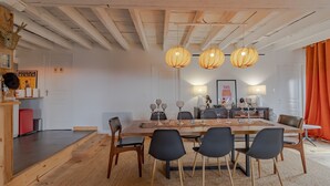 A dining area with a wooden table, black chairs, and hanging light fixtures. - Holiday Home 'La Dordogne En Périgord' with Private Pool, Private Terrace and Wi-Fi (Salagnac)