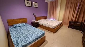 Un dormitorio con dos camas, una mesita de noche y un cabecero de madera.
