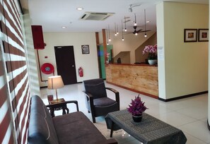 A hotel lobby with a reception desk, seating area, and a staircase. - Hotel O Pavilion Inn Hotel (Lumut)