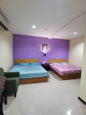 A room with two beds, a desk, and a chair.