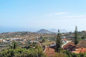 A hillside village with buildings, trees, and a distant mountain range. - Vacation Rental 'Apartamento Brownie' with Sea View, Private Terrace and Wi-Fi (Firgas)