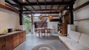 Eine geräumige Küche mit Holzschränken, ein Essbereich mit Tisch und Stühlen sowie eine gemütliche Sitzecke mit einer Couch.