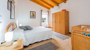 A bedroom with a bed, bedside table, lamp, wardrobe, and a window. - "Domina" Holiday Home with Private Garden (Pula)