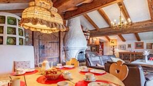 Een gezellige eethoek met een houten tafel gedekt voor een maaltijd, omringd door comfortabele zitplaatsen.