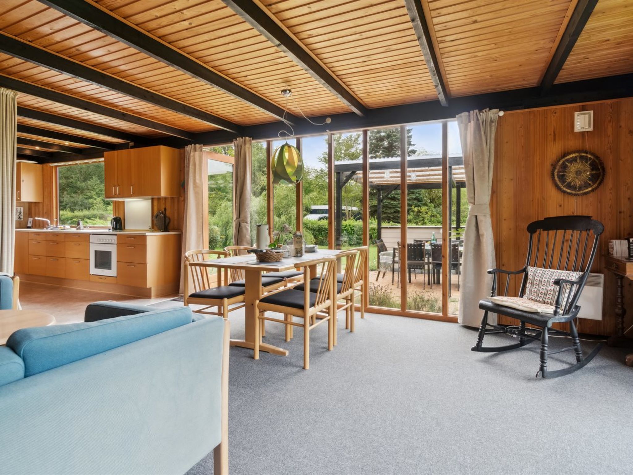 Cozinha moderna com armários de madeira e um espaço de refeições com mesa e cadeiras.