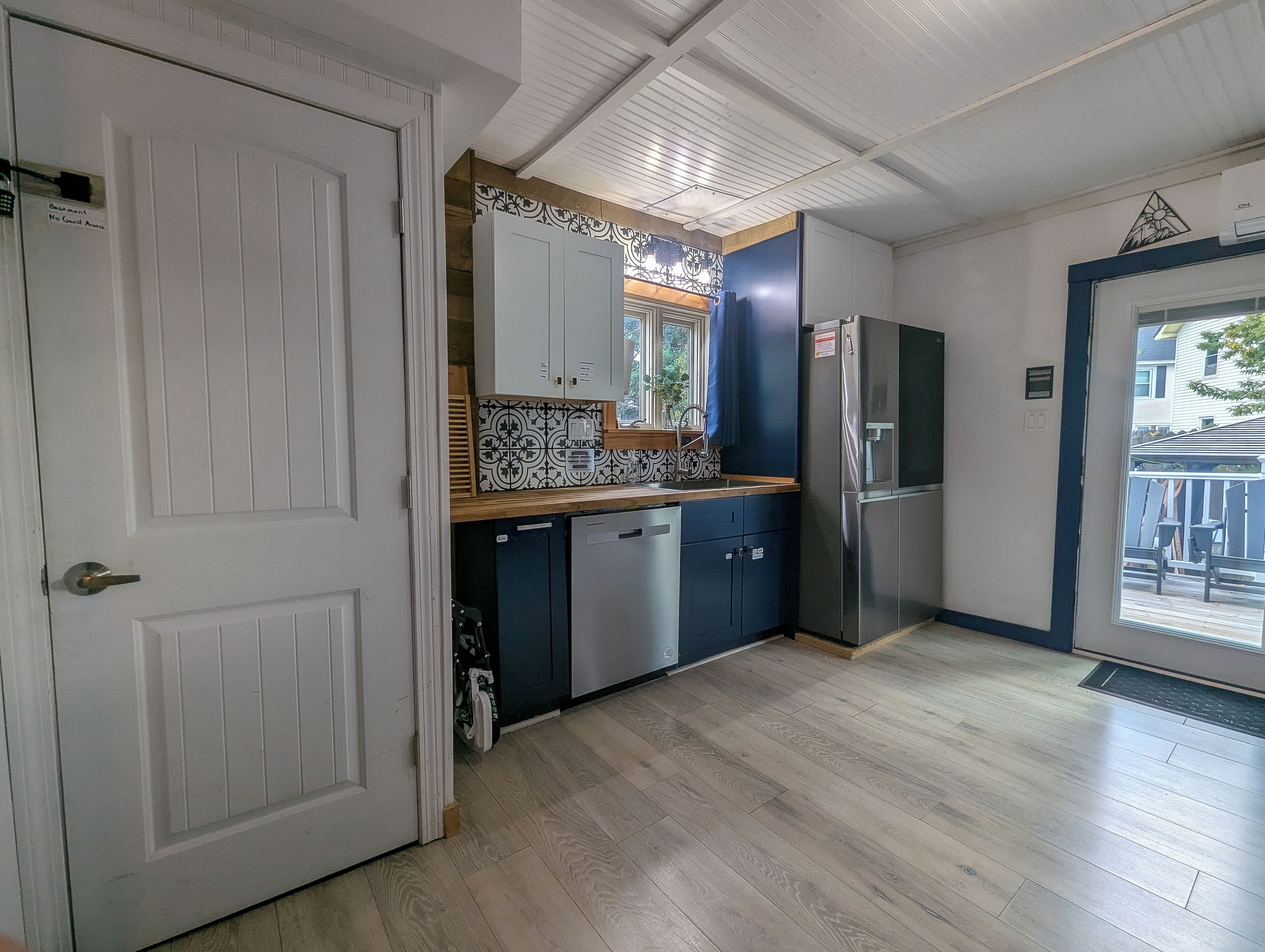 A kitchen with white cabinets, a dishwasher, and a refrigerator.