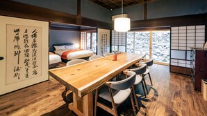 Een traditionele Japanse kamer met tatami vloerbedekking, een laag houten plafond en een schuifdeur met kalligrafie.