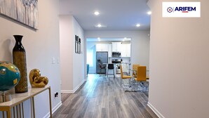 A modern kitchen with white cabinets and stainless steel appliances.