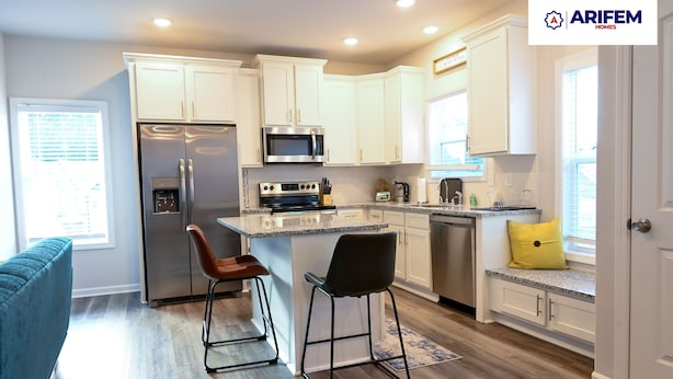 A modern kitchen with white cabinets, stainless steel appliances, and a granite countertop.