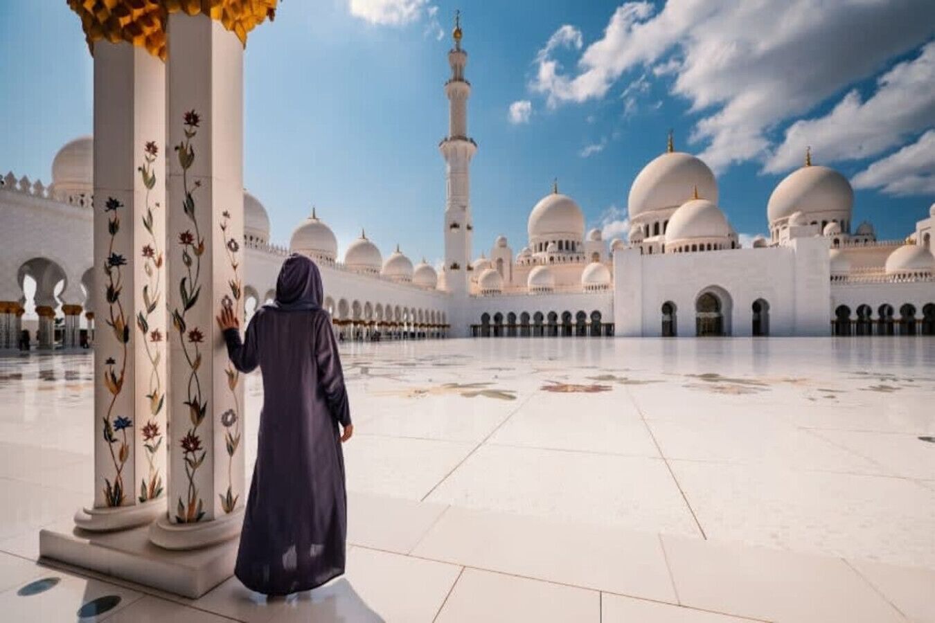 A large, open courtyard with white domed buildings and tall minarets, featuring a person in traditional attire.