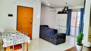 A living room with a dining table, sofa, and a chandelier. - Vacation home - Tourist rental "Belvedere House Holiday Syracuse Ortigia" (Siracusa)