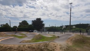 A skate park with ramps and a basketball court.