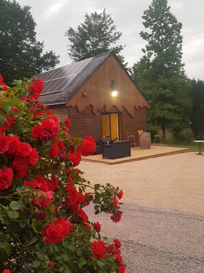 Une cabane en bois avec une allée en gravier et un espace patio.