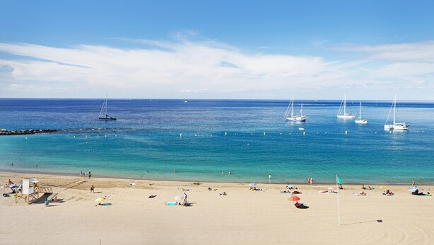 A beach with clear blue water, boats, and people. - Vacation Apartment 'Las Fuentes' with Sea View, Private Terrace and Wi-Fi (Arona)