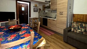 Une cuisine de taille réduite avec une table à manger, des chaises et un canapé.