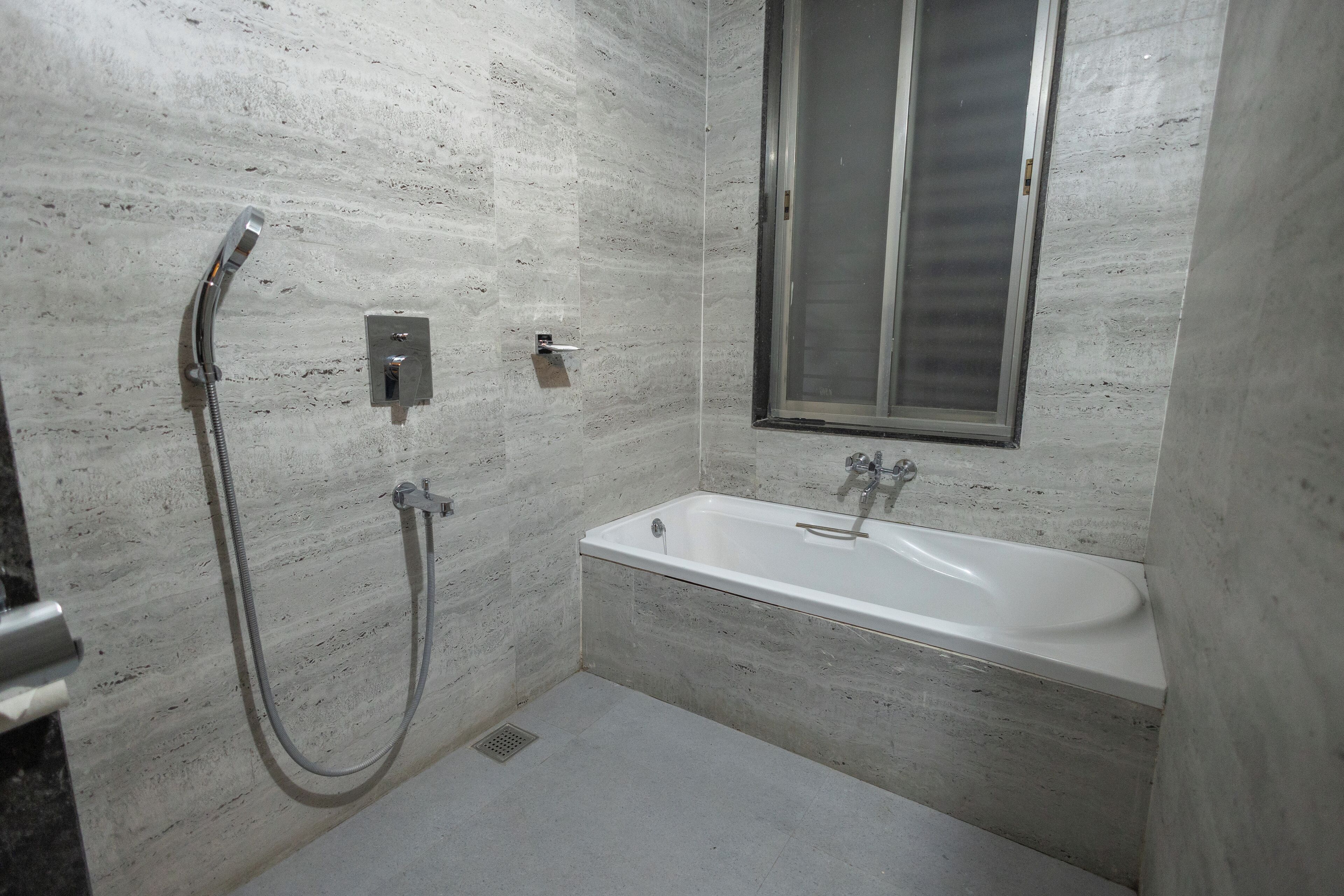 Une salle de bain avec une baignoire, une douche et une fenêtre.