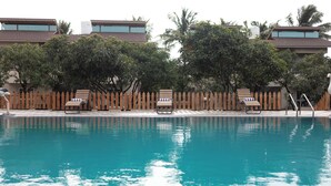 Una piscina con sillas de descanso y una valla de madera.