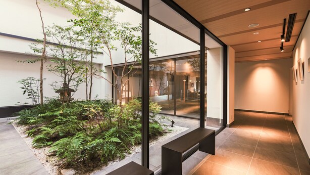 A modern interior with a glass wall, a small garden, and a bench. - KABIN Taka (Kyoto)