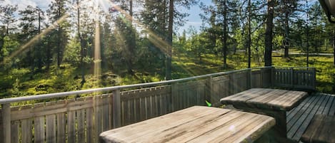 Eine Holzterrasse mit Bänken mit Blick auf eine bewaldete Landschaft.