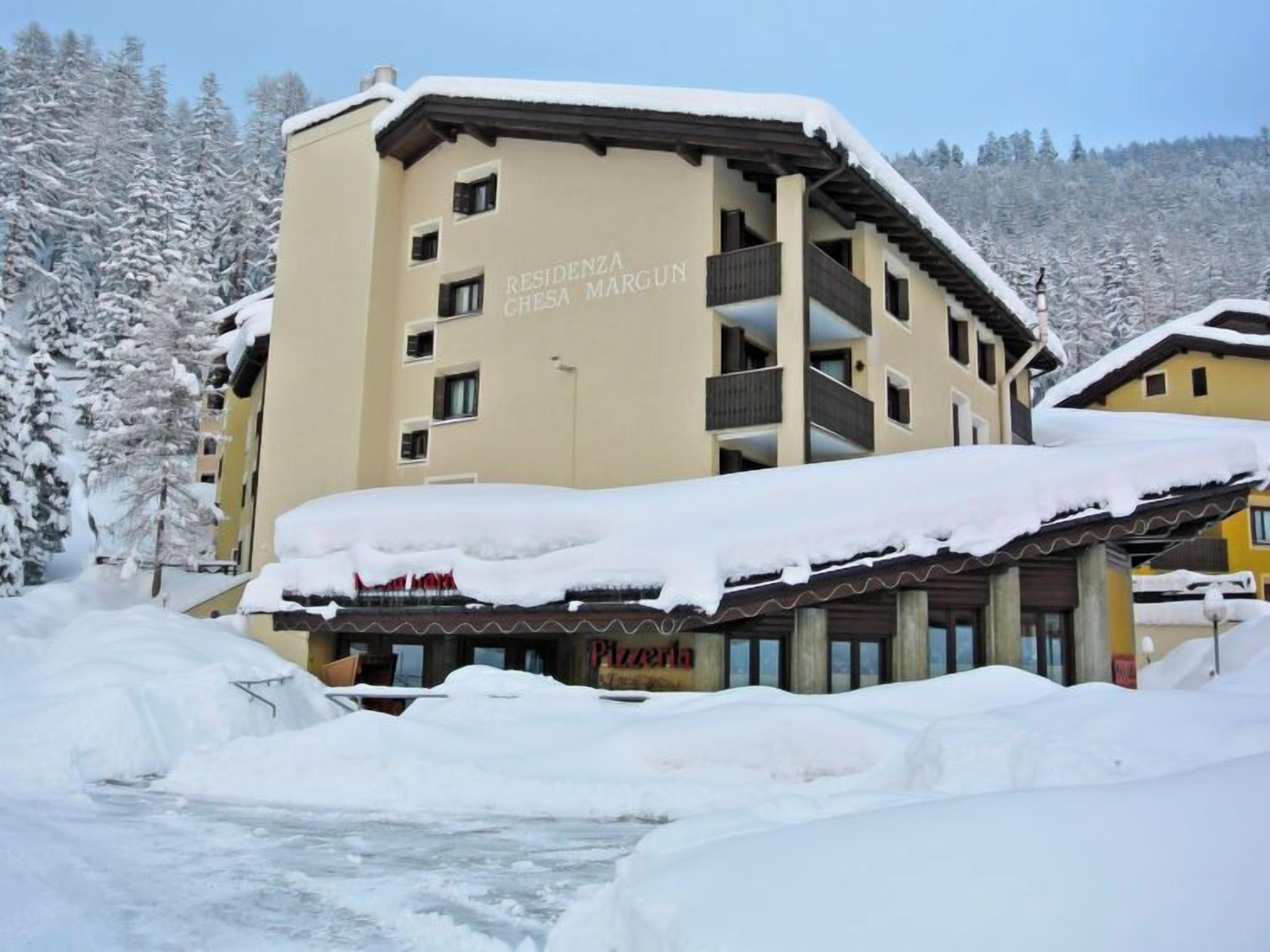 A multi-story hotel with a snow-covered roof and balconies.