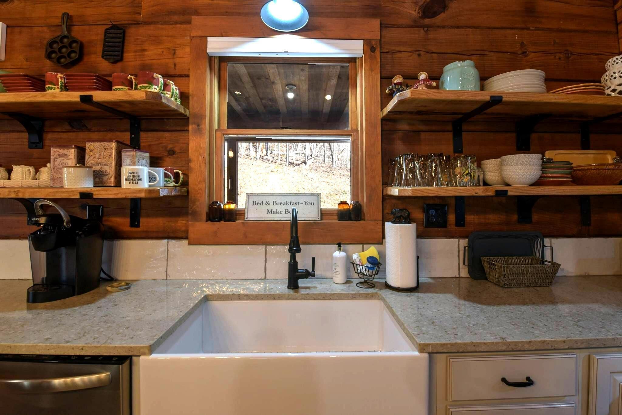 Una cucina con una finestra, scaffali in legno e un cartello che riporta la scritta 'Bed & Breakfast - You Make It'.