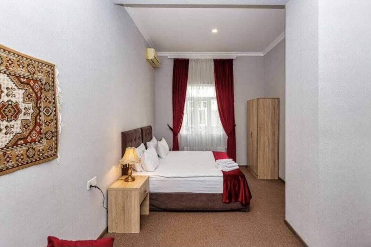 Une chambre d’hôtel comprenant un lit, une table de chevet, une lampe et une armoire.