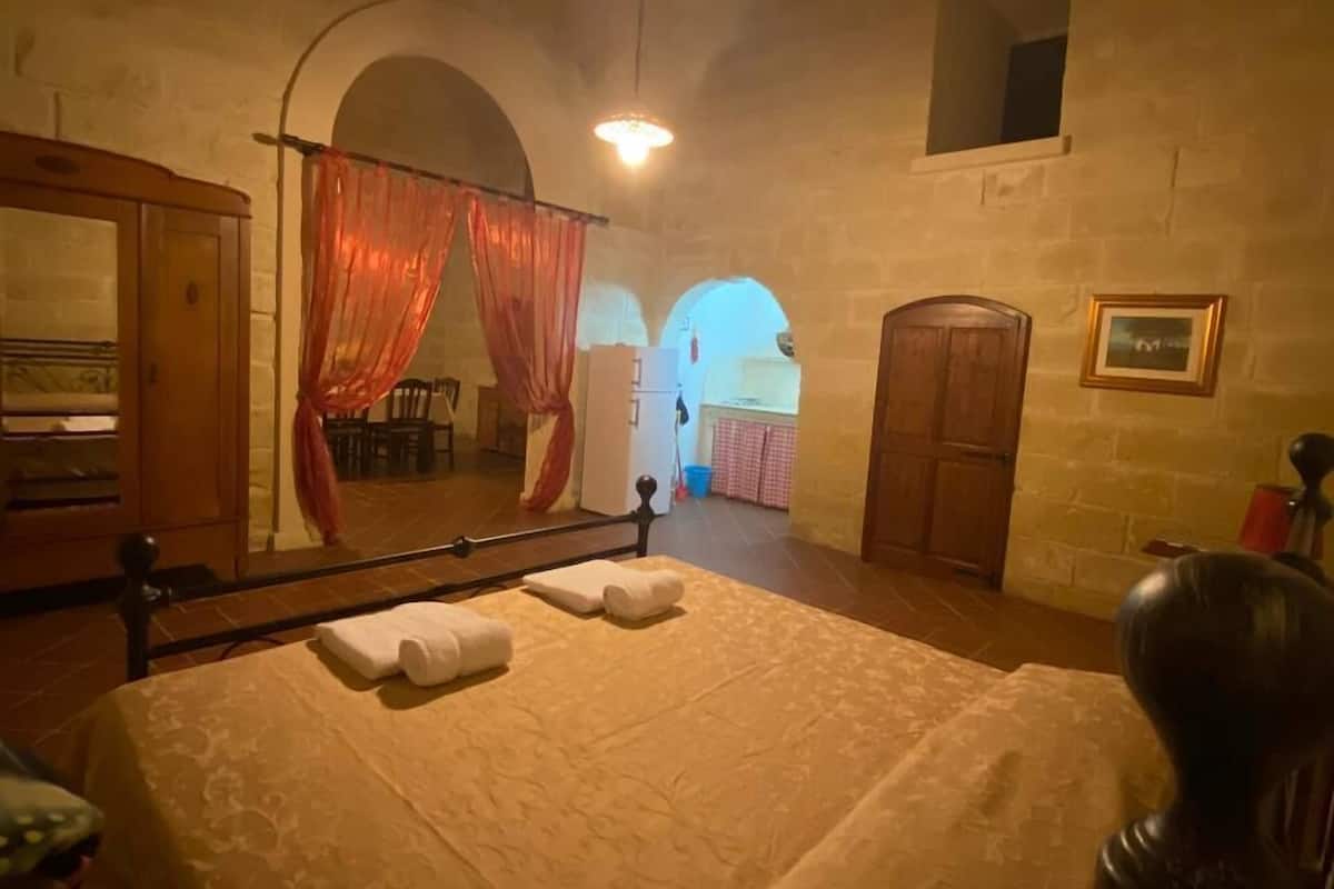 Una habitación con cama, espejo y armario de madera.