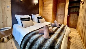 Un dormitorio tipo cabaña de madera con cama, almohadas y manta.