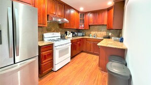 A kitchen with wooden cabinets, stainless steel appliances, a gas stove, and a microwave.