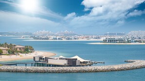Un resort costero con playa, muelle y puerto deportivo con yates.