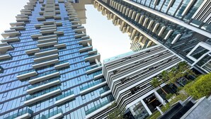 A modern high-rise building with a unique angular design, featuring multiple balconies and large windows.