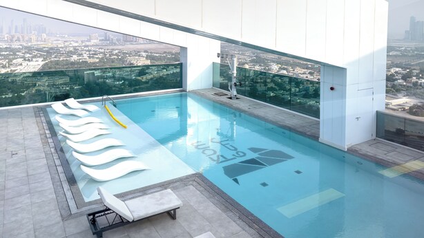 A modern rooftop pool with clear views of a cityscape.