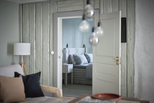Une chambre avec un mur en bois, un lit avec des oreillers, une table de chevet et une lampe.