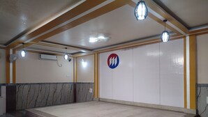 Una habitación amplia con un banco de diseño marmolado, un televisor de pantalla plana grande y un logotipo en la pared.