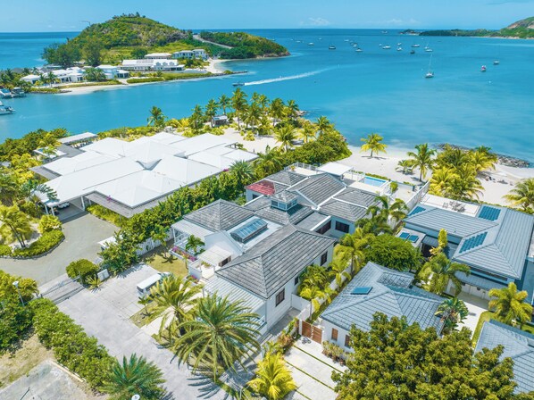 A resort with multiple buildings, a beach, and boats in the background. - Luxurious Villa Antigua/Hot Tub/Private beach/Pool (Jolly Harbour)