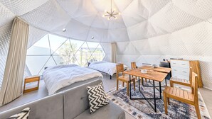 A modern, geometric interior with a central dining table, two beds, and a sofa. - Innosense Resort -In Chiba Resol- (Sanmu)