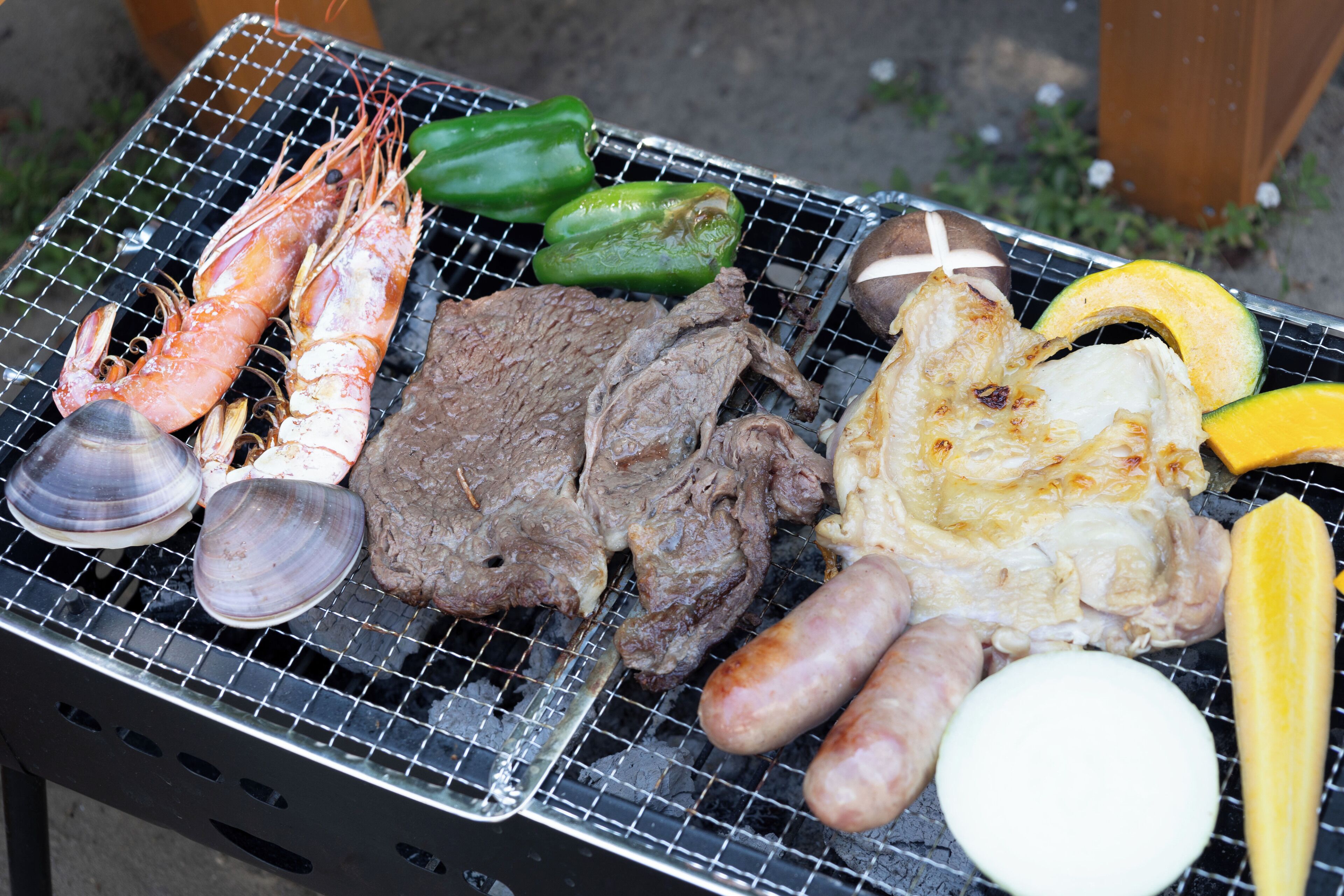 A grill with various meats and vegetables.